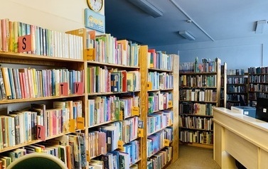 Widok pomieszczenia bibliotecznego ciasno wypełnionego regałami z książkami