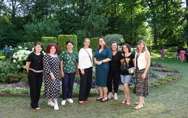 8 kobiet pozuje do grupowej fotografii.