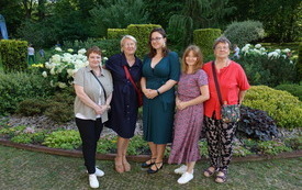 Pisarka oraz 4 kobiety na wspólnej fotografii. W tle roślinność.