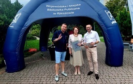 Dyrektorka biblioteki z artystą i prowadzącym spotkanie.