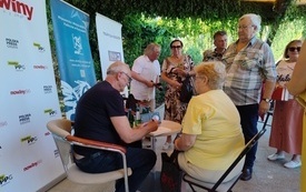 Pisarz rozdaje autografy czytelnikom. 