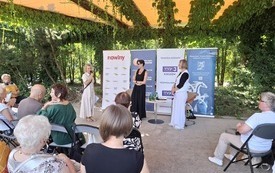 Zielone otoczenie, trzy kobiety na środku sceny.