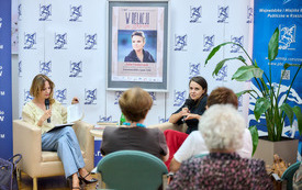 Dwie kobiety podczas rozmowy. Przed nimi publicznośc.