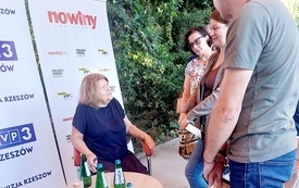 Gość spotkania starsza kobieta rozmawia z publicznością.