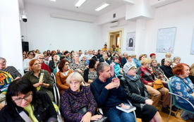 Publiczność zgromadzona na spotkaniu w sali bibliotecznej. 