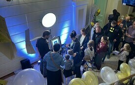 Grupa os&oacute;b oczekujących w kolejce na wykonanie cyfrowego portretu z motywem g&oacute;rskiego pejzażu.