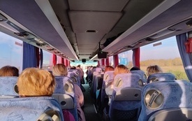 Wnętrze autobusu z pasażerami. 