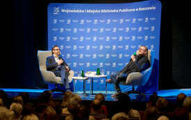 Dw&oacute;ch mężczyzn na scenie rozmaiwjących. 