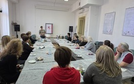 Kilkanaście kobiet w sali warsztatowej. 