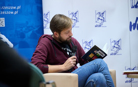 Mężczyzna czytający na głos swoją książkę. 