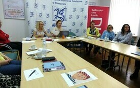 Przy stole grupa kobiet, w tle baner z pegazem.