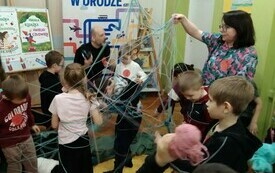 Mężczyzna i kobieta prowadzący warsztaty dla dzieci z poplątanymi sznurkami. 