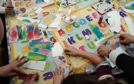 Dzieci malujące pastelami swoje obrazy. 