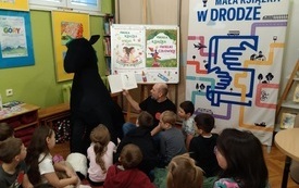 Mężczyzna czytający dzieciom podczas warsztat&oacute;w. 