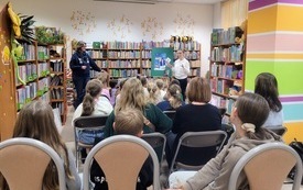 Bibliotekarka przemawia do uczestnik&oacute;w spotkania autorskiego. 