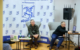 Autor i prowadzący patrzą na ekran z prezentacją