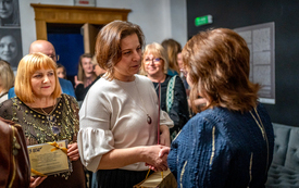 Dyrektorka biblioteki odbiera prezenty od gości jubileuszu