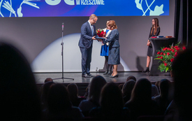 Mężczyzna przekazuje kobiecie kwiaty i prezent