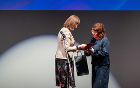 Dwie kobiety przekazują sobie prezent w ozdobnej torebce