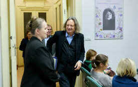 Mężczyzna w marynarce wchodzi do sali w kt&oacute;rej zgromadziła się publiczność.