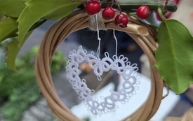 Na k&oacute;łku z wikliny zawieszone haftowane serce i zielona gałązka