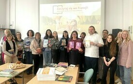 Uczestnicy spotkania pozują do wsp&oacute;lnego zdjęcia.