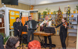 Grupa muzyków występuje przed publicznością grając na instrumentach takich jak: skrzypce, cymbały, akordeon, wiolonczela.