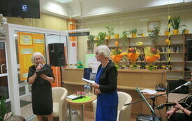 Poetka oraz prowadząca spotkanie stoją i przemawiają.