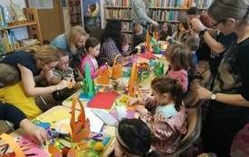 Uczestnicy warsztat&oacute;w podczas wykonywania koszyk&oacute;w wielkanocnych z kolorowego papieru.