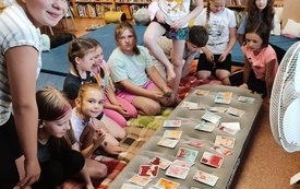 Na dmuchanym materacu rozłożone karty do gry, obok grupa dzieci