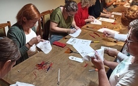 Bibliotekarki podczas warsztatów wycinanki lasowiackiej.