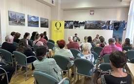 Sala konferencyjna. Mężczyzna i kobieta prowadzący rozmowę. Liczna widownia.