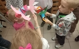 Dzieci trzymają w rękach kolorowe papierowe smoki