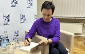 Pisarka podpisuje dedykacje dla czytelników.