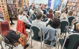 Publiczność zgromadzona na spotkaniu w bibliotece.