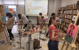 Dzieci malują obrazy w bibliotece.