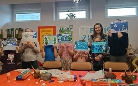 Dzieci prezentują do zdjęcia z zimowymi pracami plastycznymi.