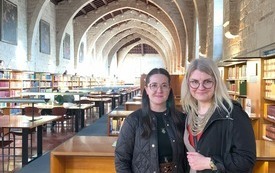 Dwie kobiety pozują do zdjęcia w zabytkowej czytelni Biblioteki Katalońskiej