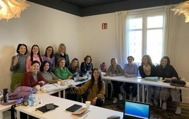 Grupa kobiet w r&oacute;żnym wieku pozuje do zdjęcia w sali lekcyjnej