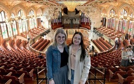 Dwie kobiety pozują do zdjęcia w zabytkowej sali koncertowej