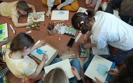 Grupa dzieci podczas rysowania obrazk&oacute;w.