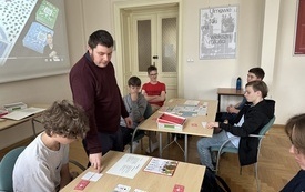 Bibliotkearz tłumaczy zasady gry chłopcom biorącym udział.