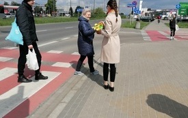 bibliotekarka na ulicy rozdaje żółte papierowe żonkile.