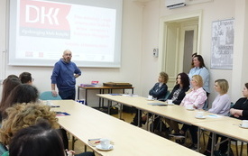 Robert Maciąg, edukator stoi i mówi do bibliotekarzy.