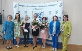 Grupa siedmiu kobiet pozuje na stojąco do wspólnego zdjęcia