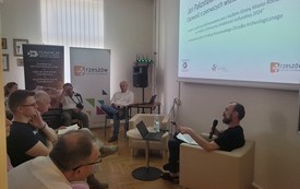 Sala konferencyjna, prelegent prowadzi wykład.