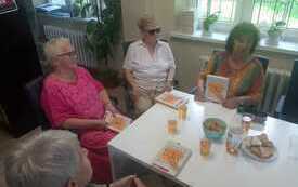 Kilka osób dyskutuje przy stole.