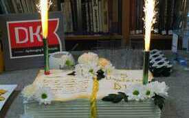 Tort w kształcie książki i logo DKK.