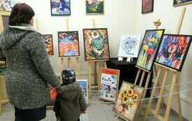 Mama z dzieckiem podczas oglądania wystawy obraz&oacute;w. 