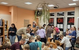 Tłum dzieci i rodzic&oacute;w w biliotecznej sali